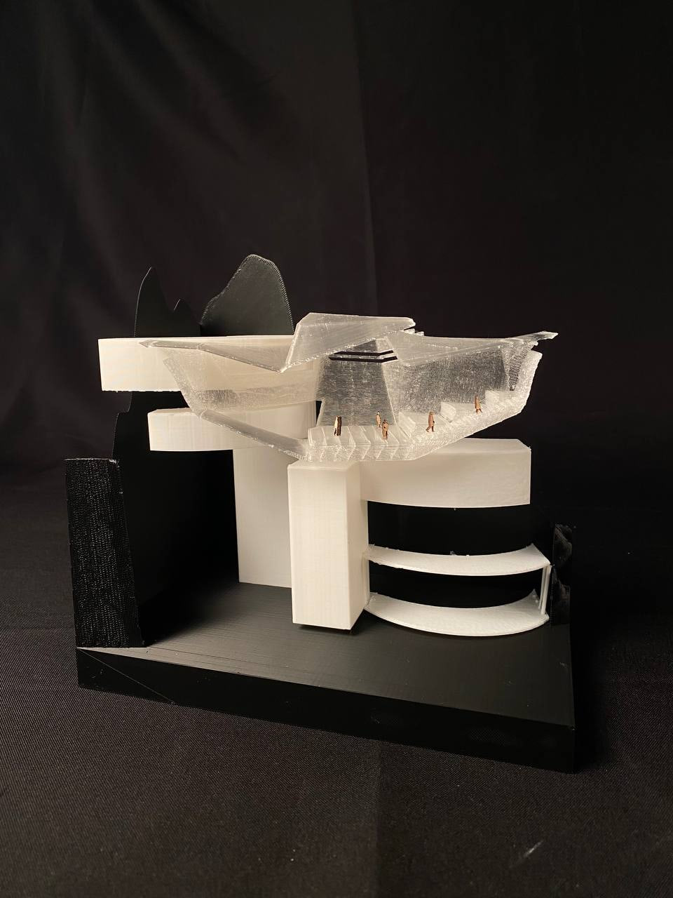 Physical model: black cast cliffs, white plates, translucent draped roof